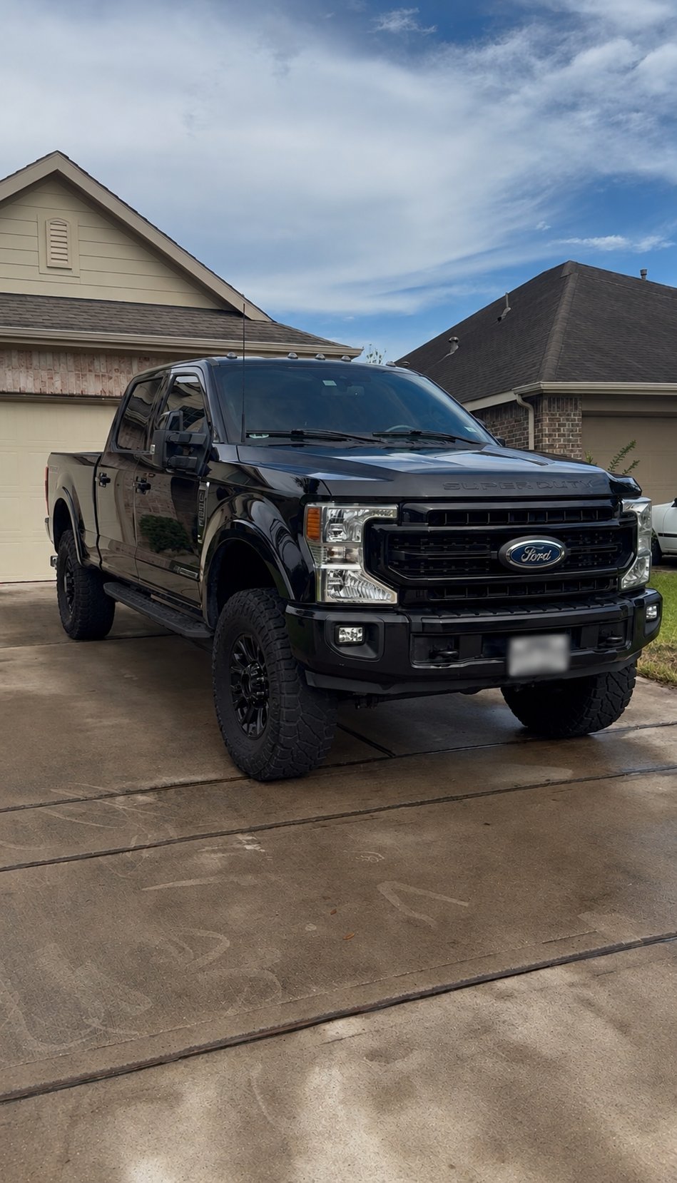 Black Ford Super Duty pickup truck freshly detailed in driveway